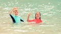 Happy children playing in sea, Smiling kids having fun in water, summer vacation with little boy and girl enjoying time